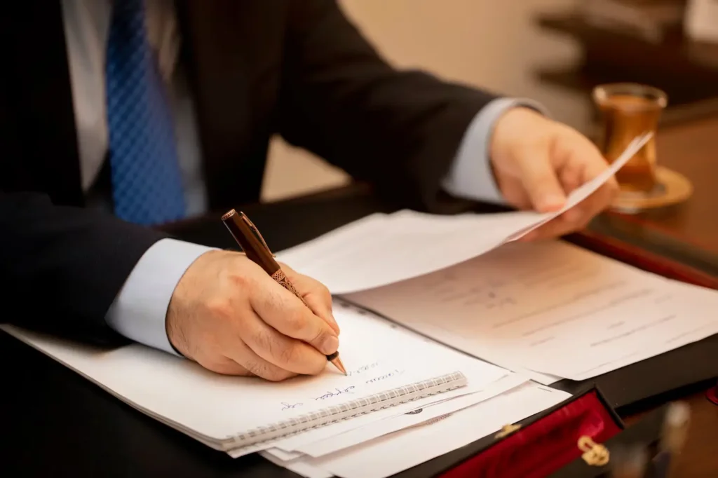 Lawyer reviewing documents and taking notes at a desk, symbolizing legal representation for tenants and landlords in Conroe, Texas.