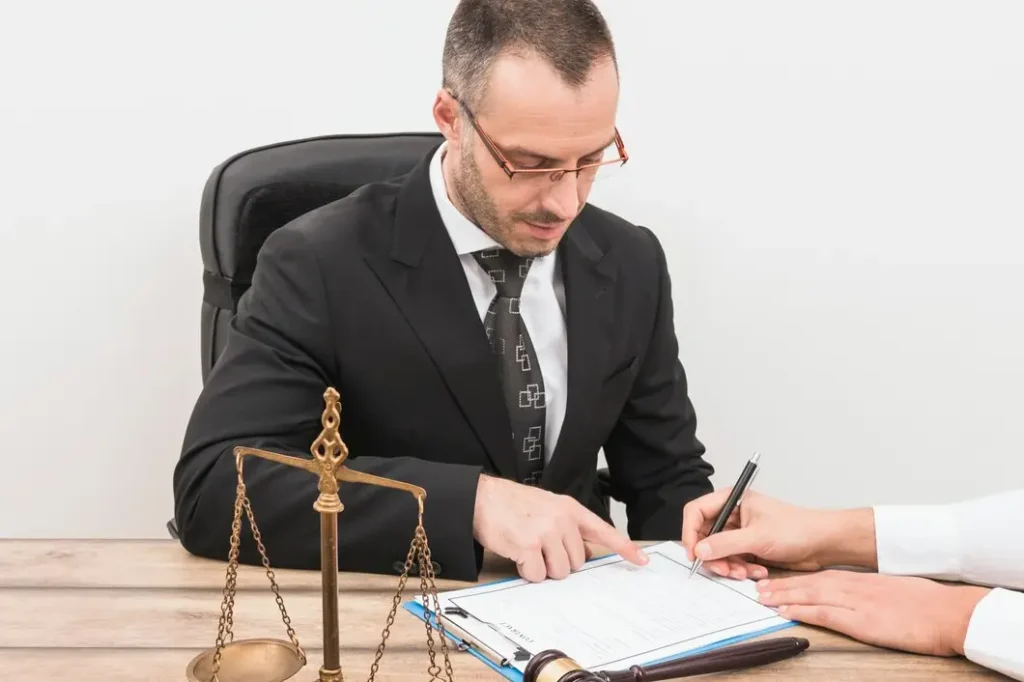 Lawyer reviewing legal documents with client, gavel and scales of justice on table, representing tenant law services in Denton County, Texas.
