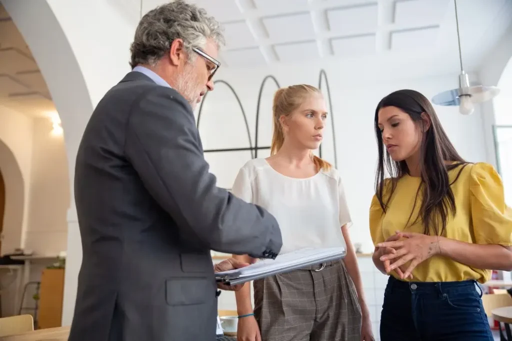 Lawyer consulting with two women about tenant rights and lease agreements in a modern office setting.