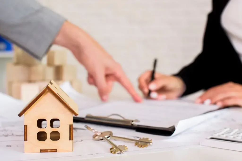 Wooden house model, keys, and paperwork on table, illustrating tenant rights consultations and lease agreements in Georgian Acres.