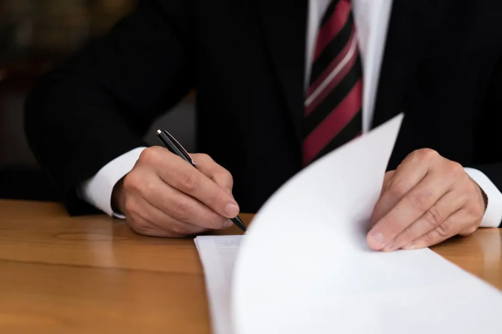 Lawyer signing a lease agreement on a wooden desk, representing tenant law services and legal assistance in Humble, Texas.