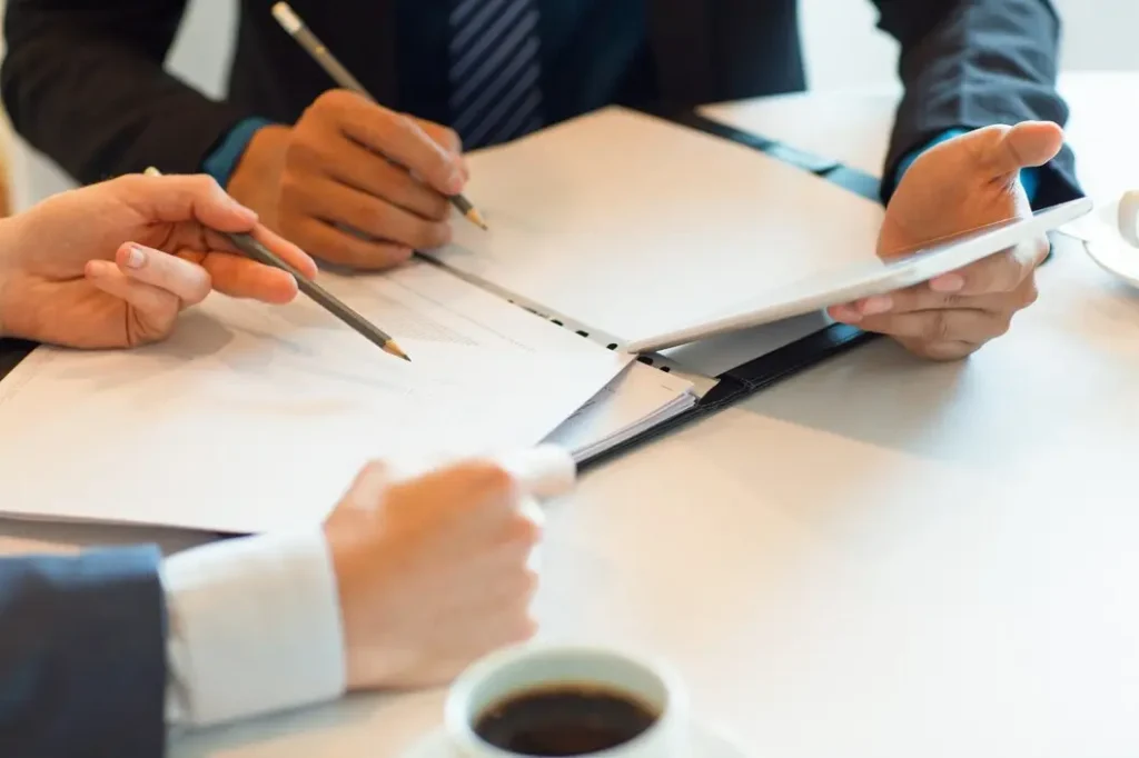 Hands engaged in a lease review discussion, with documents and pens on a table, emphasizing tenant rights legal consultation in Kingwood.