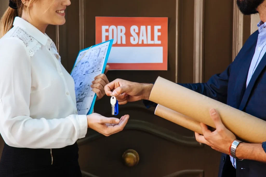 North Austin Woman receiving keys from a man in front of a "For Sale" sign, symbolizing tenant rights and property transactions in North Austin.