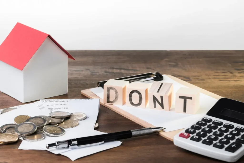 House model, coins, receipts, calculator, and wooden blocks spelling "DON'T," symbolizing tenant rights and financial awareness in North Austin tenant law context.