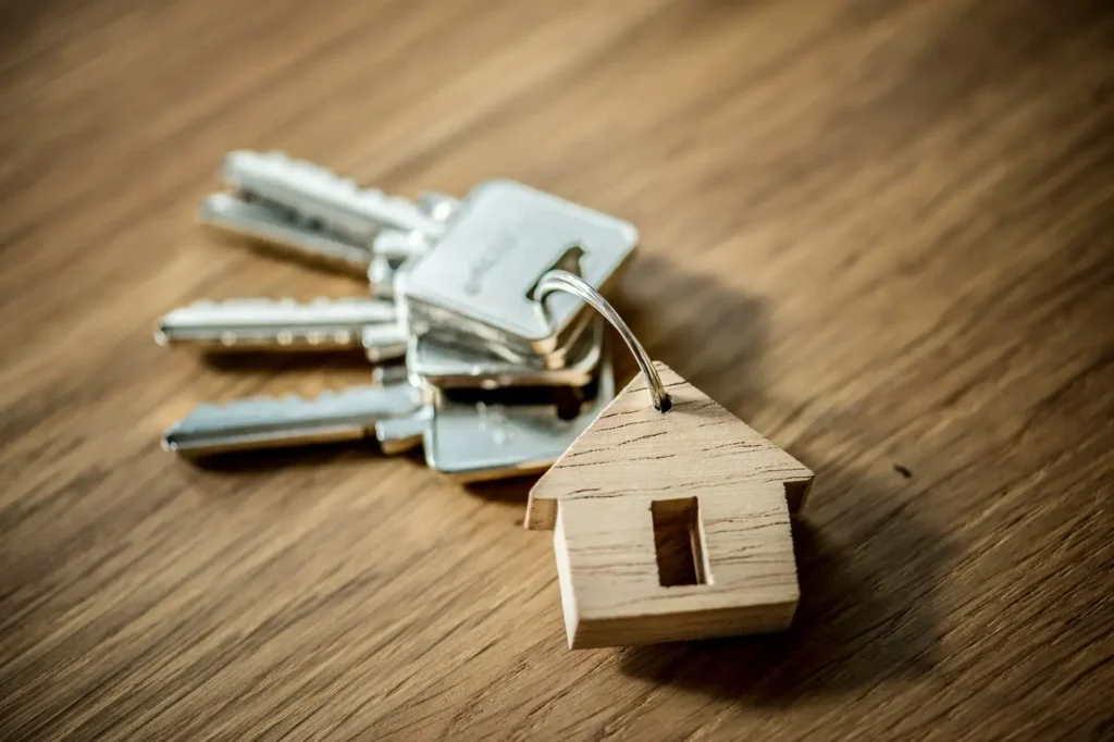 Keys with a wooden house keychain on a wooden surface, symbolizing tenant rights and housing security in North Shoal Creek.