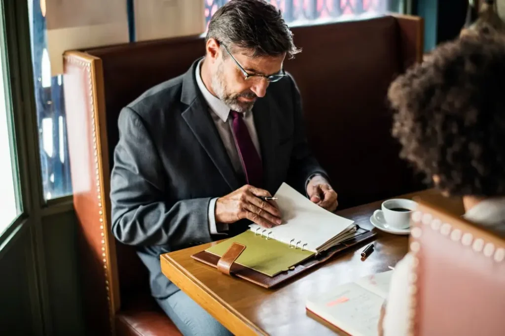 Man in a suit reviewing legal documents at a table in a caf&eacute;, symbolizing tenant law consultations in Parker County.