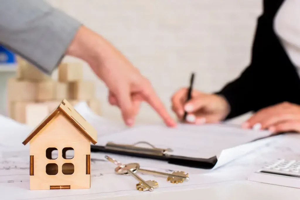 Wooden house model and keys on a table with documents, illustrating tenant rights and lease agreements in Tarrytown.