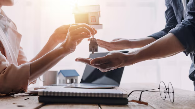 Hands exchanging house keys and a small house model, symbolizing tenant rights and legal assistance in housing matters.